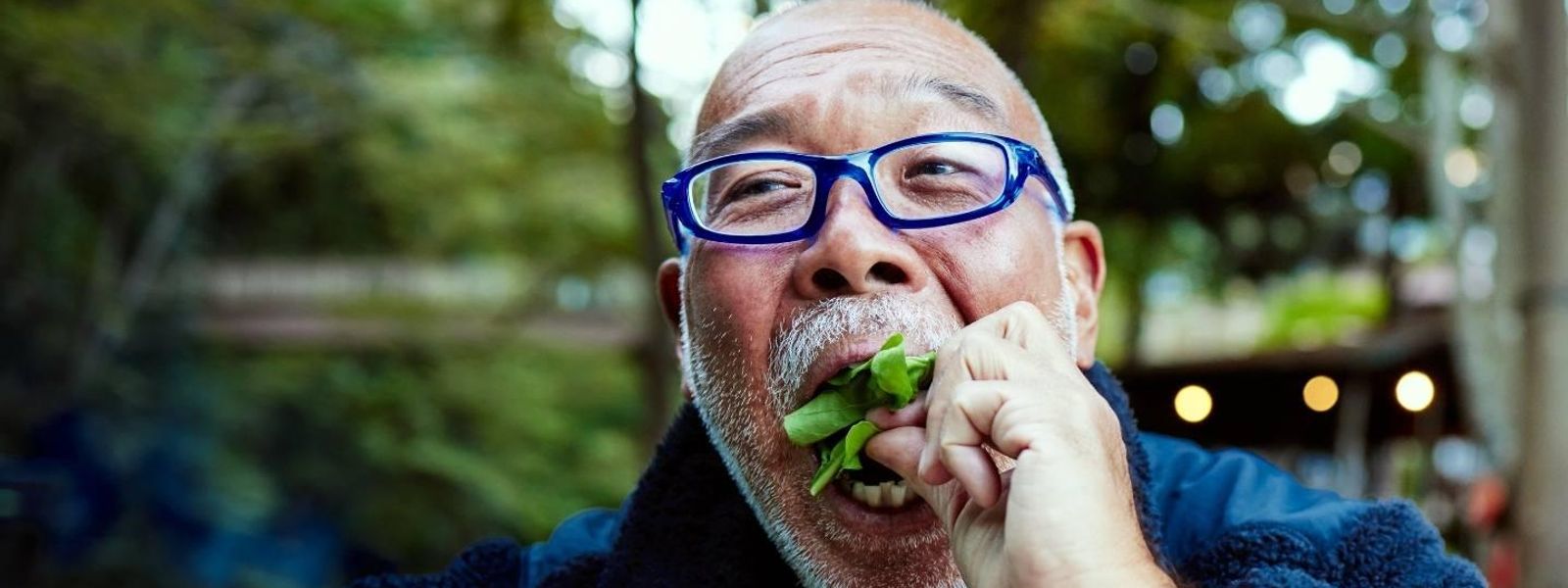 Happy man with blue glasses eating healthy